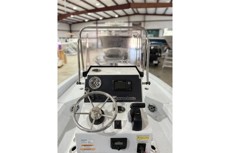 Slide: The Image of 2022 Express H20 Bay boat dashboard with steering wheel and controls in a showroom. - 21