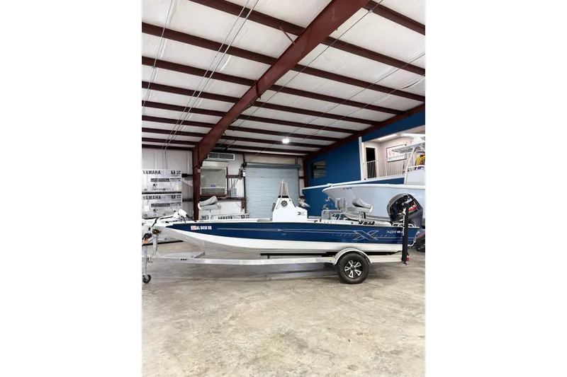 Slide: The Image of 2022 Express H20 Bay boat in a showroom, featuring a sleek blue and white design. - 3