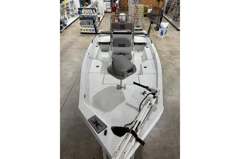 Slide: The Image of 2022 Express H20 Bay boat displayed in a showroom with fishing gear. - 5