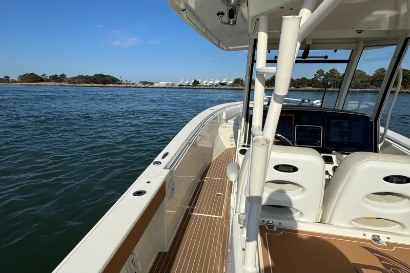 Slide: The Image of 2015 Cobia 344 Center Console boat on calm water, clear sky, and distant shoreline. - 10