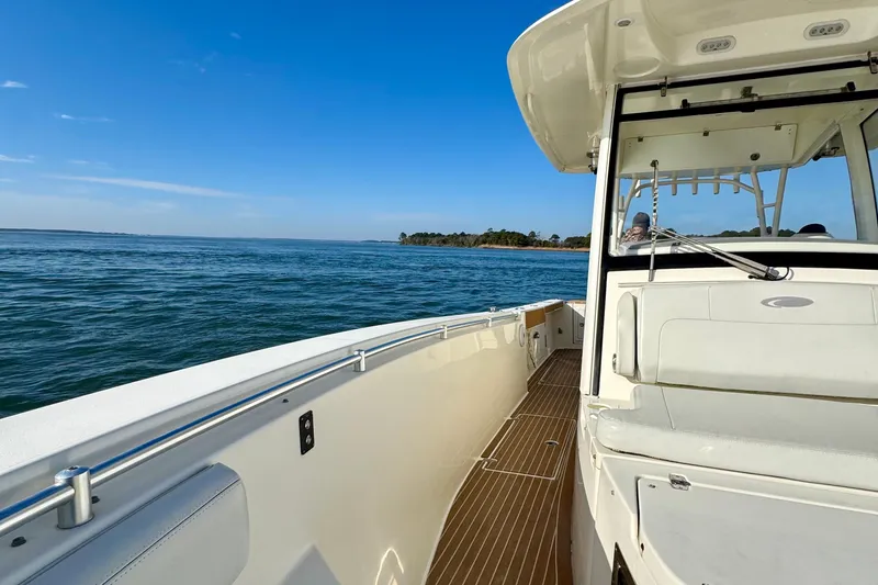 Slide: The Image of 2015 Cobia 344 Center Console boat cruising on open water under clear blue sky. - 12
