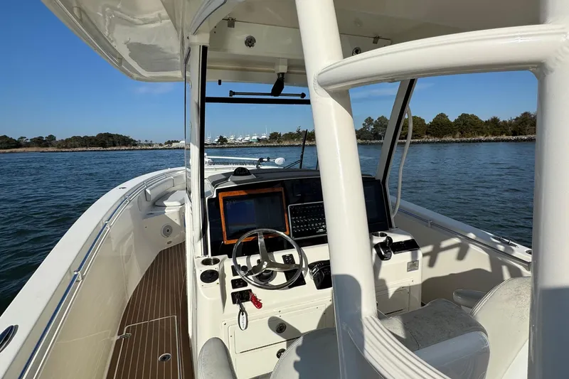 Slide: The Image of 2015 Cobia 344 Center Console boat on water, featuring helm and navigation equipment. - 14