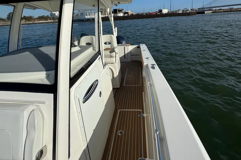 Slide: The Image of 2015 Cobia 344 Center Console boat on water, featuring sleek design and spacious deck. - 15