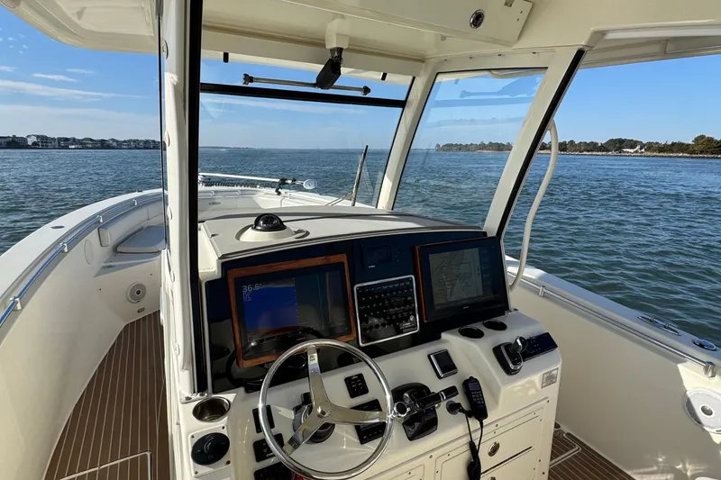 Slide: The Image of 2015 Cobia 344 Center Console boat dashboard with navigation screens on open water. - 16