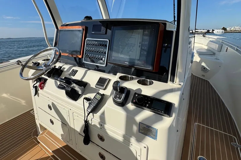 Slide: The Image of 2015 Cobia 344 Center Console boat dashboard with navigation screens and controls. - 18