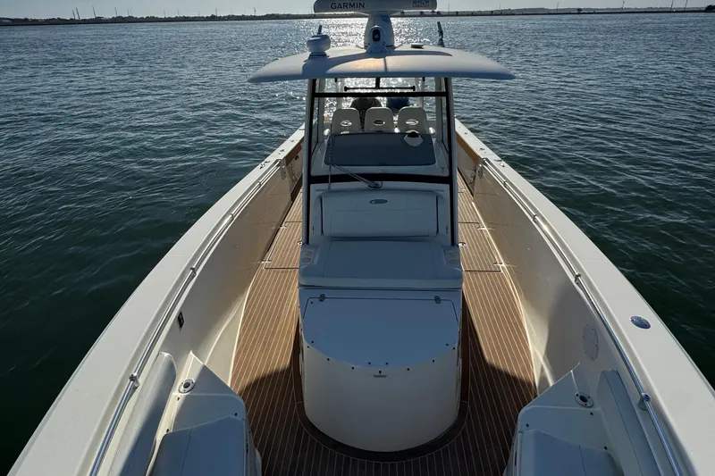 Slide: The Image of 2015 Cobia 344 Center Console boat on calm water, showcasing spacious deck and helm. - 7