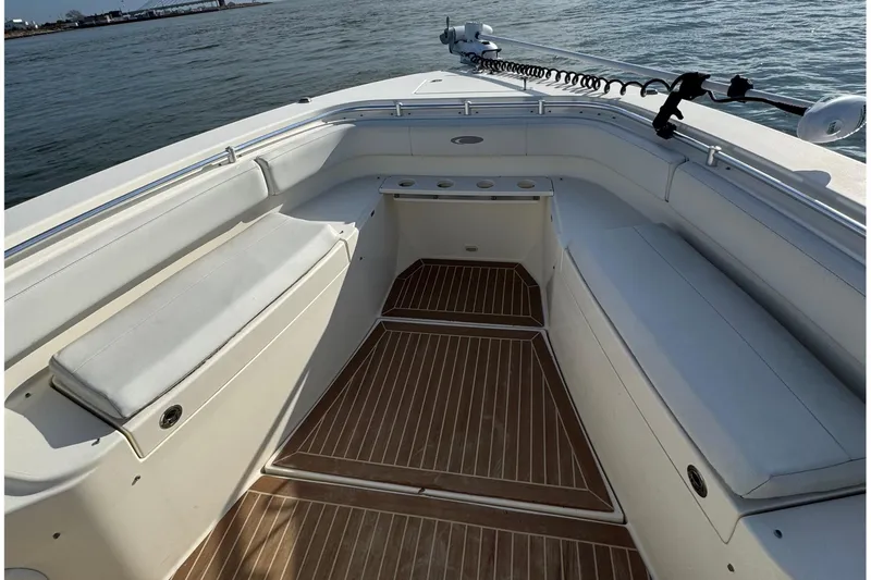 Slide: The Image of 2015 Cobia 344 Center Console boat interior with cushioned seating and wooden flooring. - 8