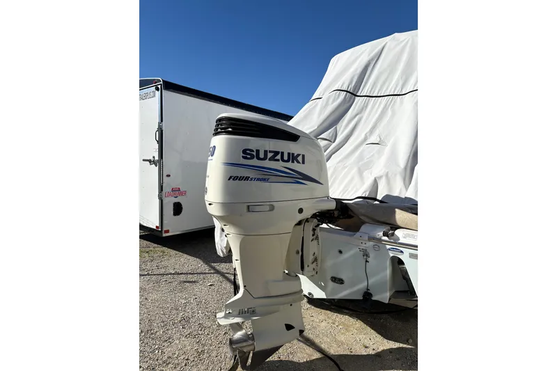 Slide: The Image of 2016 Sea Fox 249 Avenger with Suzuki outboard motor, covered and parked outdoors. - 25