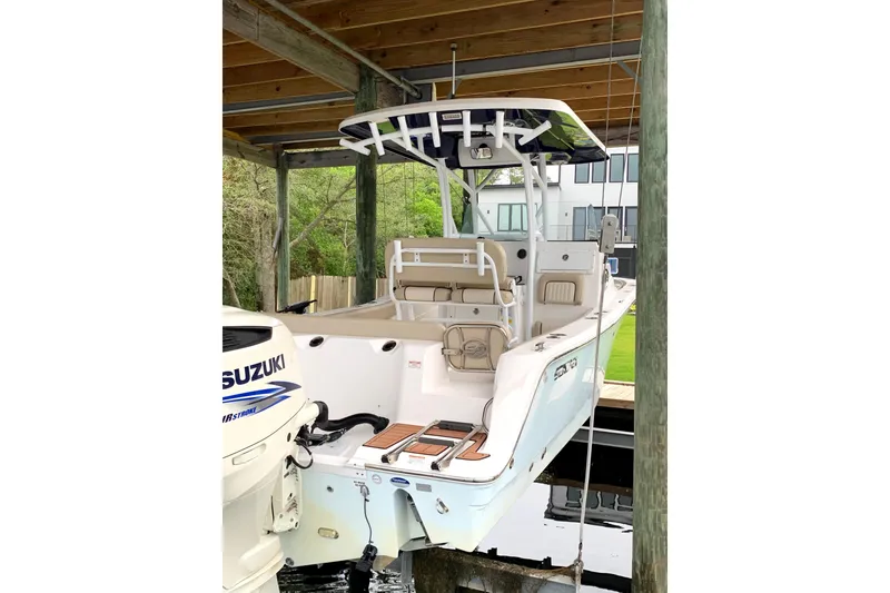 Slide: The Image of 2016 Sea Fox 249 Avenger boat with Suzuki engine, docked under a wooden shelter. - 5