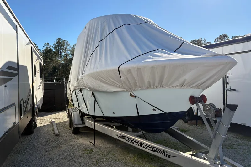 Slide: The Image of 2016 Sea Fox 249 Avenger boat covered on trailer, parked outdoors. - 9