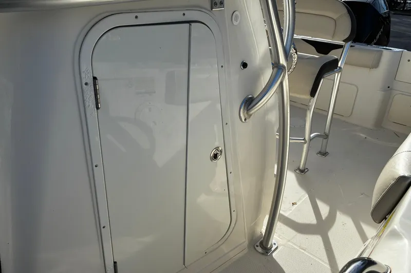 Slide: The Image of 2022 Sailfish 242 CC boat interior with door and seating area. - 13