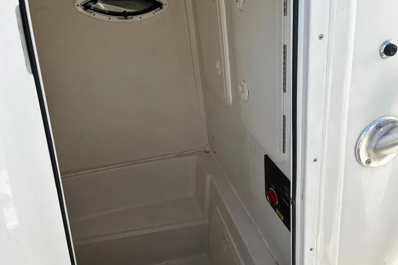 Slide: The Image of Outboard motor on 2022 Sailfish 242 CC boat, parked near a lake. - 14