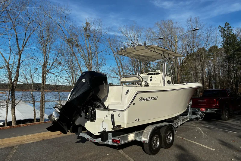 Slide: The Image of 2022 Sailfish 242 CC boat on trailer, parked outdoors near trees. - 3