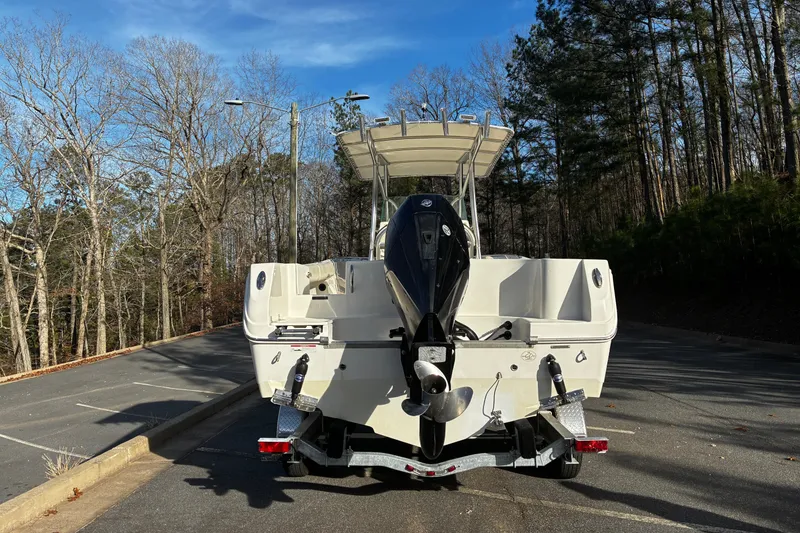 Slide: The Image of 2022 Sailfish 242 CC boat on trailer in wooded parking area. - 4