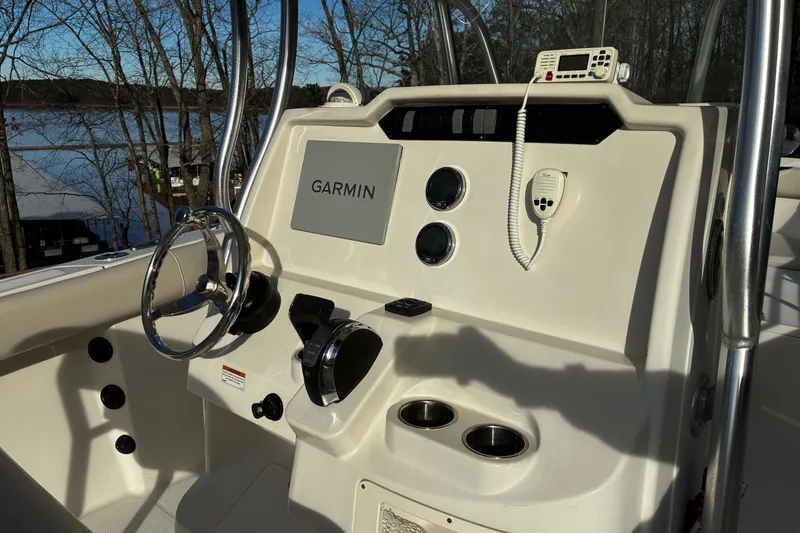 Slide: The Image of 2022 Sailfish 242 CC boat console with steering wheel, controls, and display screen. - 7