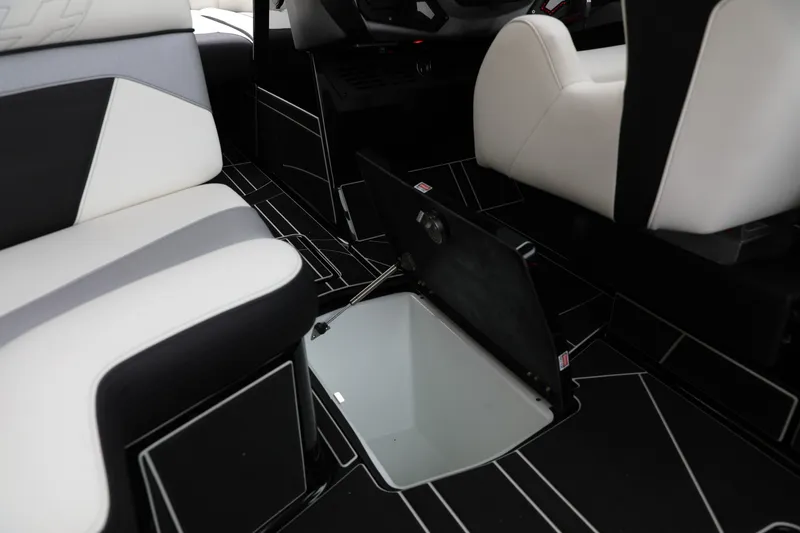 Slide: The Image of 2026 Centurion Ri245 interior with open storage compartment, featuring modern black and white seating. - 16