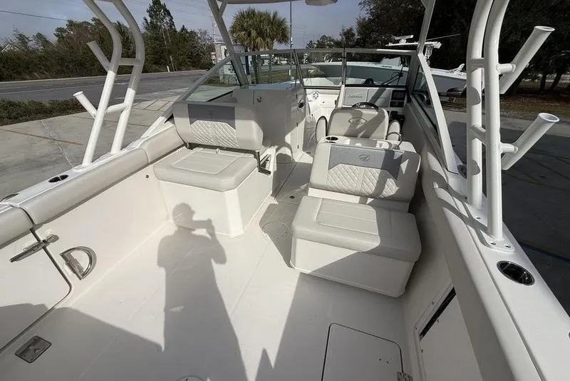 Slide: The Image of 2026 Sailfish 276 DC boat interior with seating and rod holders, docked outdoors. - 15