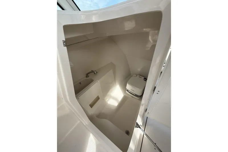 Slide: The Image of Interior of 2026 Sailfish 276 DC boat, featuring compact bathroom with toilet and sink. - 22