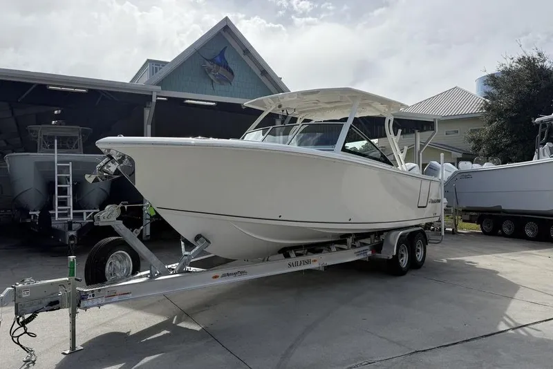 Slide: The Image of 2026 Sailfish 276 DC boat on trailer in marina setting. - 4