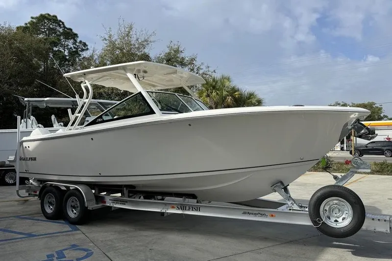Slide: The Image of 2026 Sailfish 276 DC boat on trailer, parked outdoors under cloudy sky. - 5