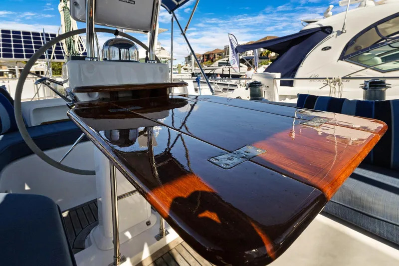 Slide: The Image of Polished wooden table on 2009 Hylas 46 yacht, with steering wheel and marina view. - 19