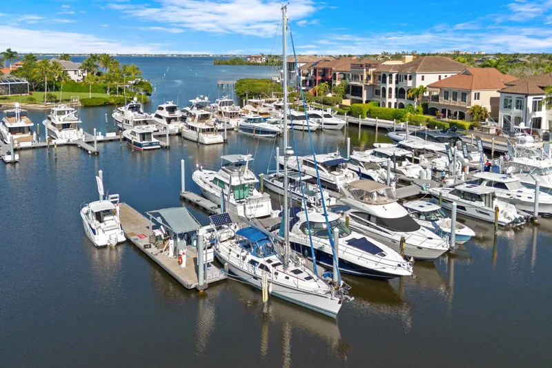 Slide: The Image of Marina with various boats, featuring a 2009 Hylas 46 sailboat docked among luxury yachts. - 2