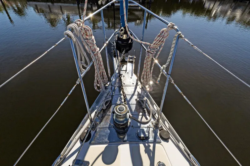 Slide: The Image of Bow of 2009 Hylas 46 sailboat with ropes and winch, reflecting sunlight on water. - 3