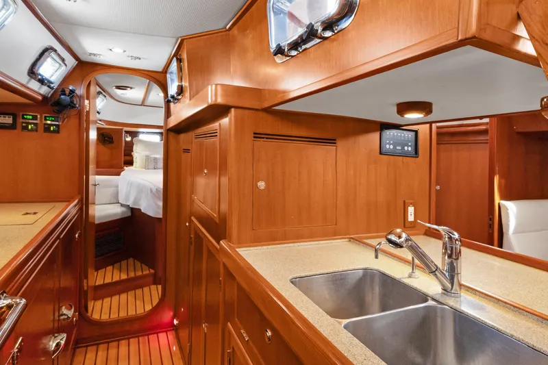 Slide: The Image of Luxurious 2009 Hylas 46 yacht interior with wooden cabinetry and modern kitchen amenities. - 33
