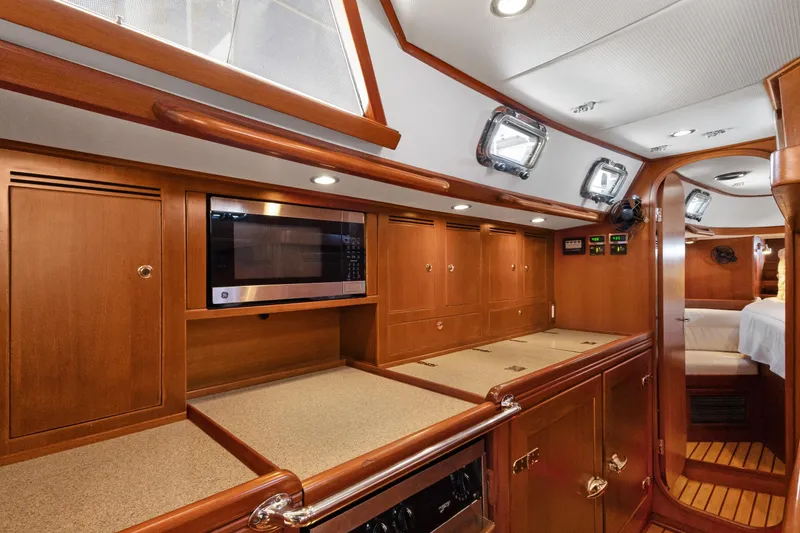 Slide: The Image of Luxurious 2009 Hylas 46 yacht interior with wood cabinetry and modern appliances. - 34