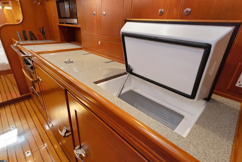 Slide: The Image of Luxurious 2009 Hylas 46 yacht interior with wooden cabinetry and open storage compartment. - 37
