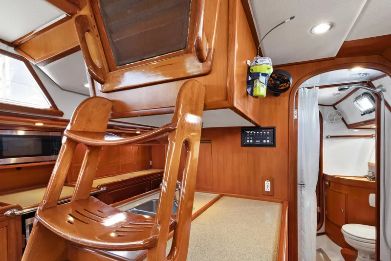 Slide: The Image of Interior of a 2009 Hylas 46 yacht featuring a wooden finish and compact bathroom. - 47
