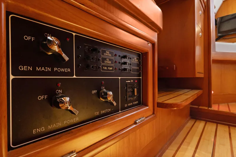 Slide: The Image of Control panel inside 2009 Hylas 46 yacht, featuring power switches and wooden interior. - 59
