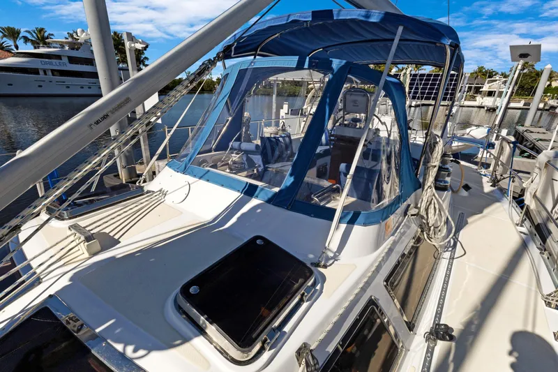 Slide: The Image of 2009 Hylas 46 sailboat with blue canopy docked in marina under clear sky. - 6