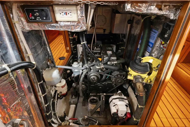 Slide: The Image of Engine room of a 2009 Hylas 46 yacht, showcasing mechanical components and wiring. - 61