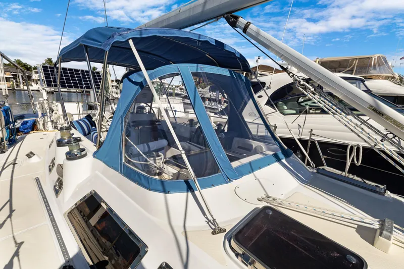 Slide: The Image of 2009 Hylas 46 sailboat with blue canopy and solar panels in marina. - 9