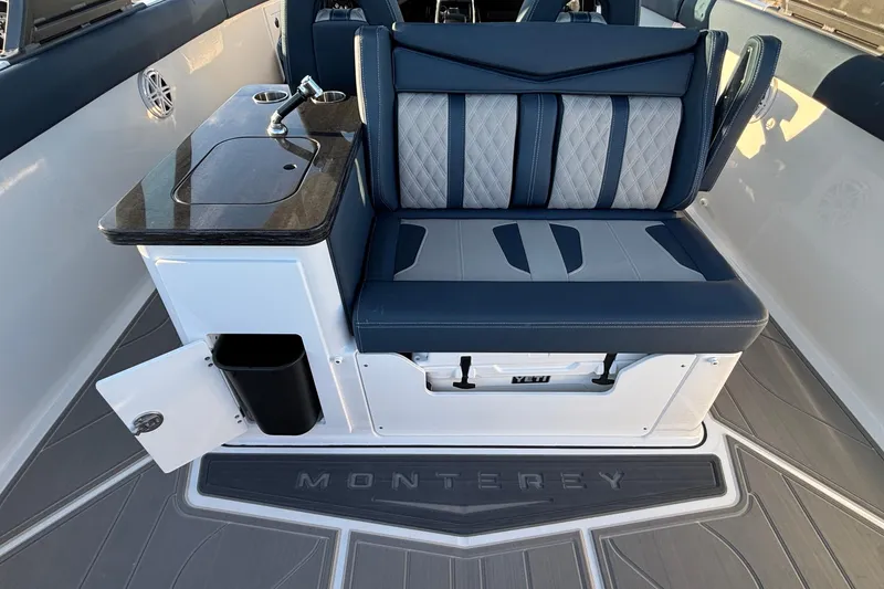 Slide: The Image of 2026 Monterey Elite 30 OB boat interior with cushioned seating and built-in sink. - 12