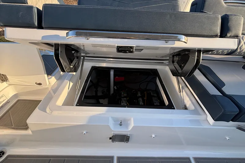 Slide: The Image of 2026 Monterey Elite 30 OB boat with open storage compartment and cushioned seating. - 17