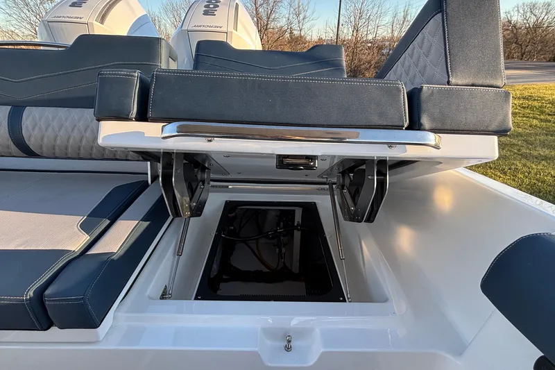 Slide: The Image of 2026 Monterey Elite 30 OB boat with open storage compartment and cushioned seating. - 19