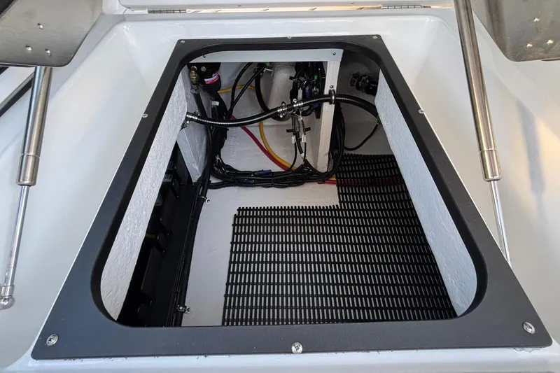 Slide: The Image of Open storage compartment in 2026 Monterey Elite 30 OB boat, showcasing wiring and equipment. - 20