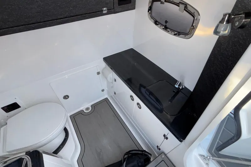 Slide: The Image of 2026 Monterey Elite 30 OB boat bathroom with toilet, sink, and window. - 38