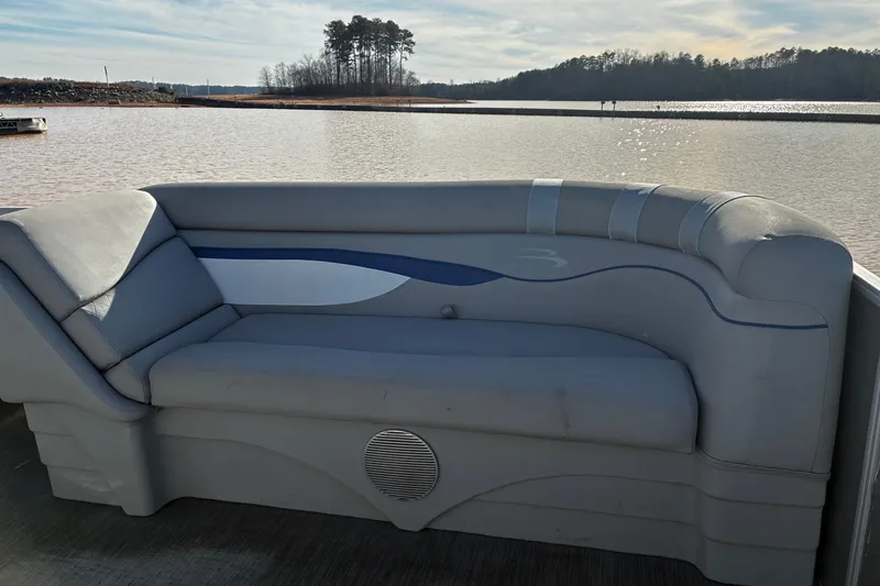 Slide: The Image of 2023 Bennington 22 SSR boat interior with gray seating, lake view in background. - 11