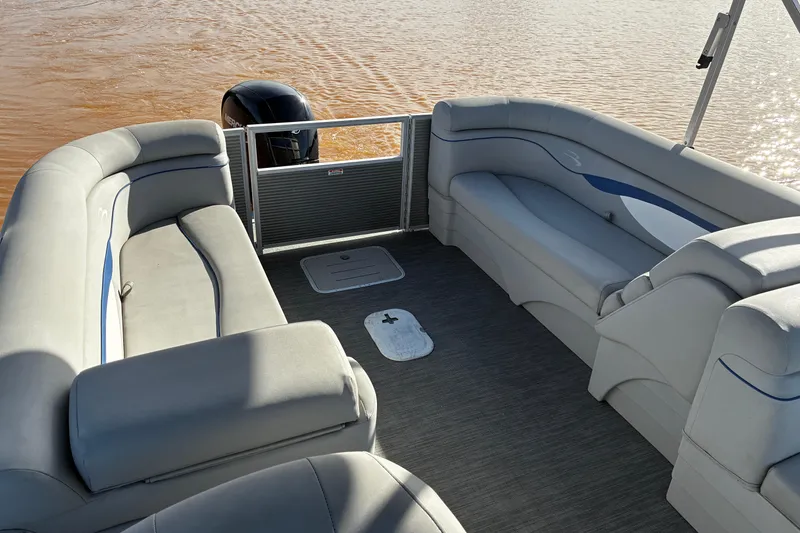 Slide: The Image of 2023 Bennington 22 SSR pontoon boat interior with plush seating on calm water. - 14