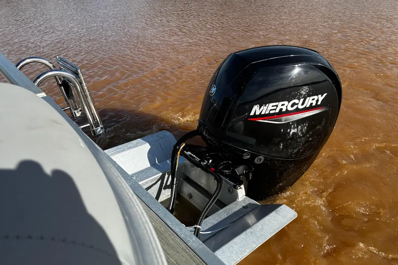 Slide: The Image of 2023 Bennington 22 SSR boat with Mercury outboard motor on brown water. - 15