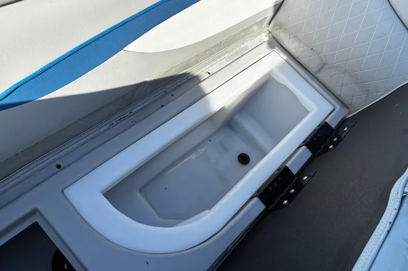 Slide: The Image of 2023 Bennington 22 SSR boat storage compartment with blue and white upholstery. - 18