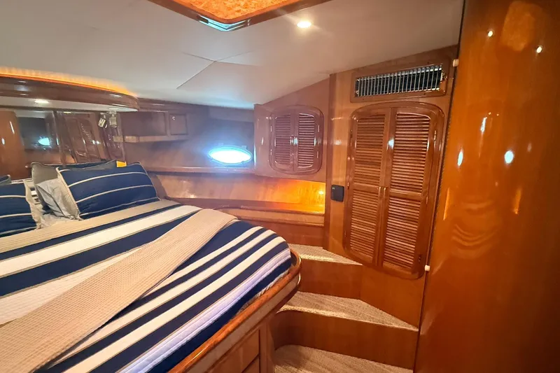 Slide: The Image of Luxurious cabin interior of 2003 Mikelson 50 yacht with striped bedding and wooden finishes. - 10