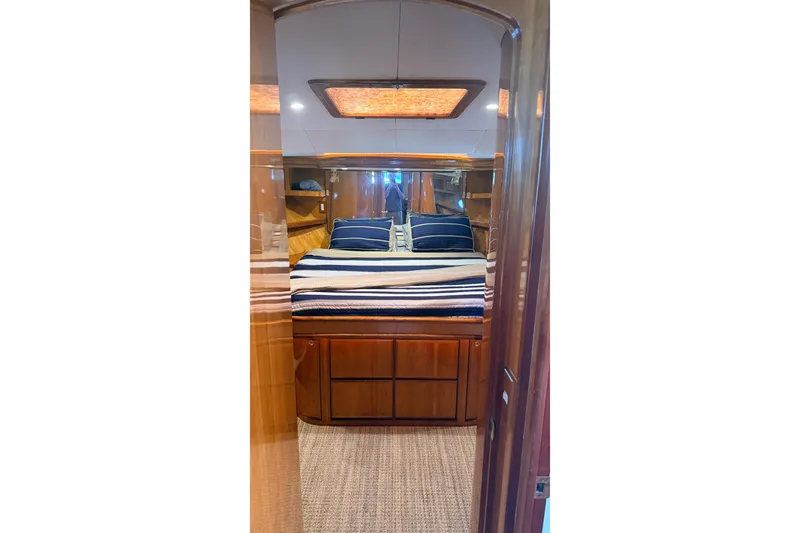 Slide: The Image of Luxurious cabin interior of 2003 Mikelson 50 yacht with wooden furnishings and striped bedding. - 13