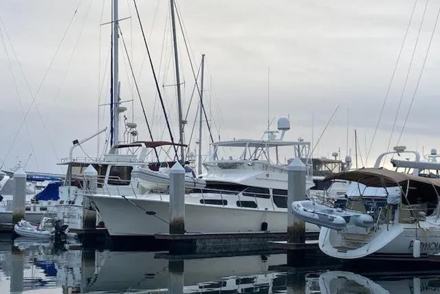 Slide: The Image of Boats docked at a marina, featuring a 2003 Mikelson 50 yacht. - 2
