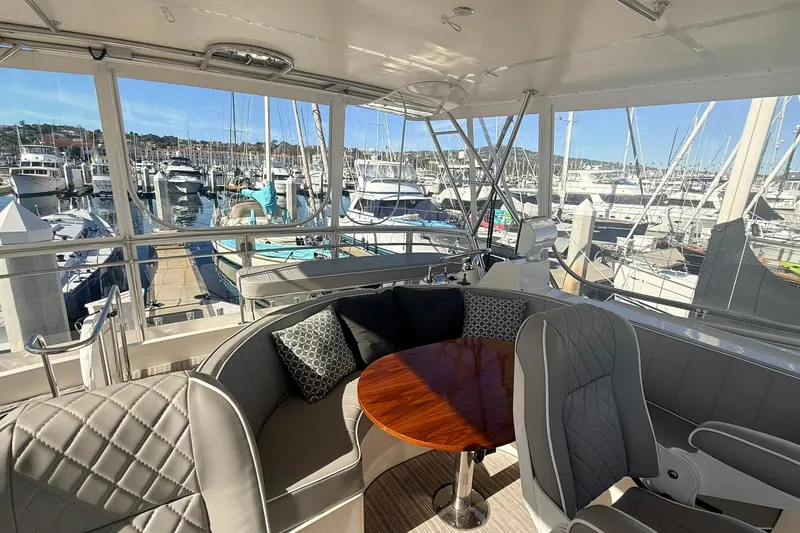 Slide: The Image of Luxurious 2003 Mikelson 50 yacht interior with marina view, featuring elegant seating and table. - 25