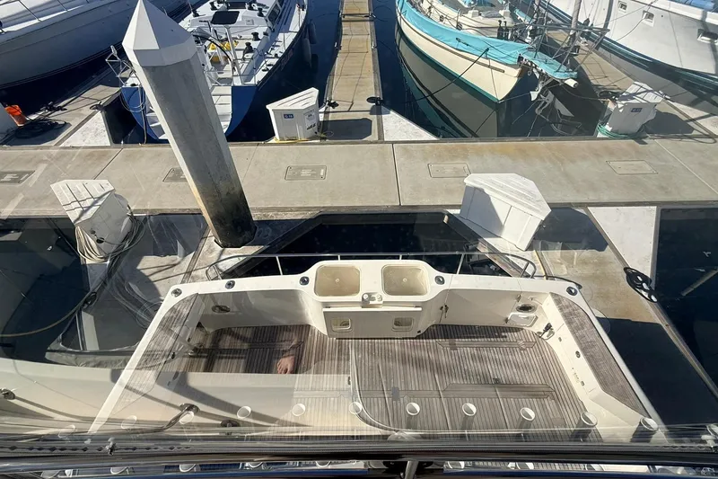 Slide: The Image of 2003 Mikelson 50 yacht docked at marina, view of deck and surrounding boats. - 26