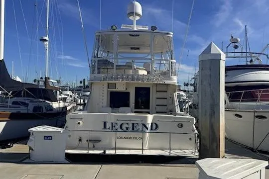 Slide: The Image of 2003 Mikelson 50 yacht named "Legend" docked at a marina under clear skies. - 3